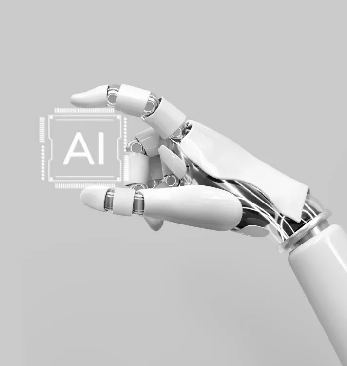 A robotic hand holding a chip marked AI